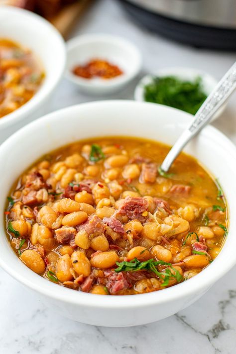 Prepare a steaming bowl of Southern comfort with these Instant Pot Ham and Beans, a perfect way to make the most of leftover ham. In this cozy dish, white beans are cooked in a rich ham-infused broth until they achieve a soft and creamy texture.This ham and beans recipe is somewhere between a soup and a stew and is cozy and delicious! Instant Pot Ham And Beans, Ham And Beans Recipe, Beans And Ham, Instant Pot Ham, Southern Comfort Food, Ham And Beans, Ham And Bean Soup, Comfort Food Southern, Leftover Ham