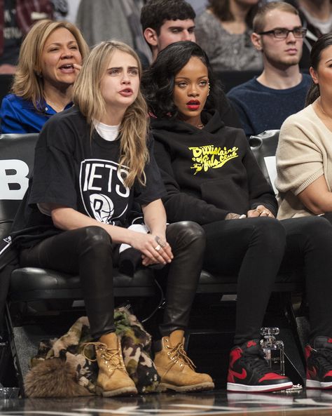 Cara Delevingne was quite the sport in Nets gear when she joined good pal Rihanna's cheering section at a recent game. Sports Game Outfits For Women, Courtside Fits, Rihanna Courtside, Gaming Outfits, Ball Game Outfit, Basketball Game Outfit Women, Basketball Game Outfit, Nba Basketball Game, Nba Game