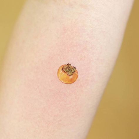 Tiny persimmon tattoo done on the inner forearm. Oranges Tattoo Fruit, Persimmons Tattoo, Dim Sum Tattoo, Mangosteen Tattoo, Tiny Fruit Tattoo, Kumquat Tattoo, Persimmon Aesthetic, Persimmon Drawing, Apricot Tattoo