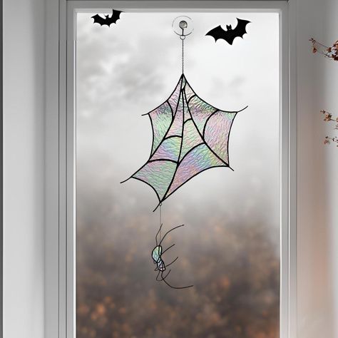 Add a touch of eerie elegance to your home with this stunning Stained Glass Spider Web and Spider Suncatcher. Perfect for Halloween and holiday decor, this handcrafted piece brings together the mysterious allure of a spider's web with the beauty of iridescent glass that shimmers as the light changes throughout the day. Each section of the web is carefully crafted to catch and refract light, creating a magical effect that transforms your windows into a focal point of gothic charm. DIMENSIONS SPID Spider Suncatcher, Iridescent Halloween, Spider Web With Spider, Stained Glass Gothic, Stained Glass Spider Web, Reputation Aesthetic, Stained Glass Spider, Glass Spider, Gothic Window