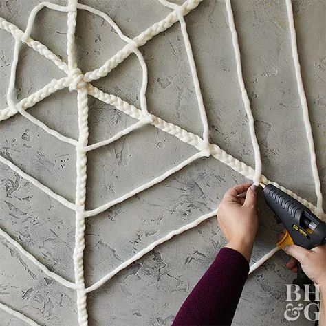 Braided Spiderweb | Better Homes & Gardens Haunted Mansion Wreath, Spiderweb Craft, Yarn Craft Ideas, Make A Spider Web, Yarn Lanterns, Diy Halloween Village, Yarn Keychain, Spider Web Halloween Decorations, Decorating On A Dime