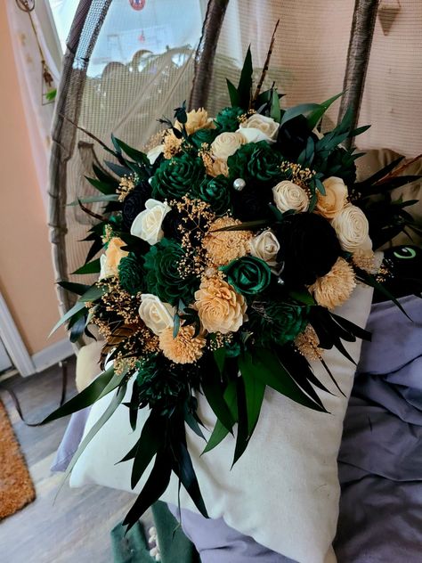 This glam 20's theme bouquet is made with wooden flowers and preserved greenery. Dark greens, black, and champagne gold are accented by ivory flowers, pearls, and pheasant feathers. Also the perfect addition to any boho themed event! Prefer a metallic gold? Message me for custom request instructions!For more information, you can view our FAQs page. To place a custom order or ask about custom changes, please send over a message - I'm happy to put together something custom for you. For matching it Wedding Green And Gold Theme, Black Green And Gold Wedding Flowers, Emerald Green Flower Arrangements, Jade Wedding Theme, Black Emerald Gold Wedding, Black And Emerald Green Wedding, Glam Wedding Bouquet, Emerald And Gold Wedding, Bouquet Prom