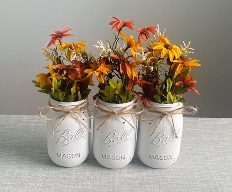 -Set of 3 hand-crafted CREAM chalk painted distressed Mason jar vases w/faux flowers included!  -Choose from colors in second photo. Mix & match Message me after purchase with color preferences.  -Add a bit of rustic charm to your home! Perfect for a gift idea, centerpiece, table top/seasonal decor, bridal or baby shower favors or decorations, wedding decor, housewarming gift, team/school colors, to brighten an office desk, bathroom or mantel.  -Jars are PINT size 16oz...5 inches high -Jars are wrapped individually & ship out a day or two after the order is placed. -I do have Quart size mason jars available as well. Please check my listings or message if interested. Mason Jar Flower Arrangements, Quart Size Mason Jars, Mason Jar Vases, Fall White, Mason Jar Flowers, Centerpiece Table, Fall Crafts Diy, Jar Vase, Mini Vase