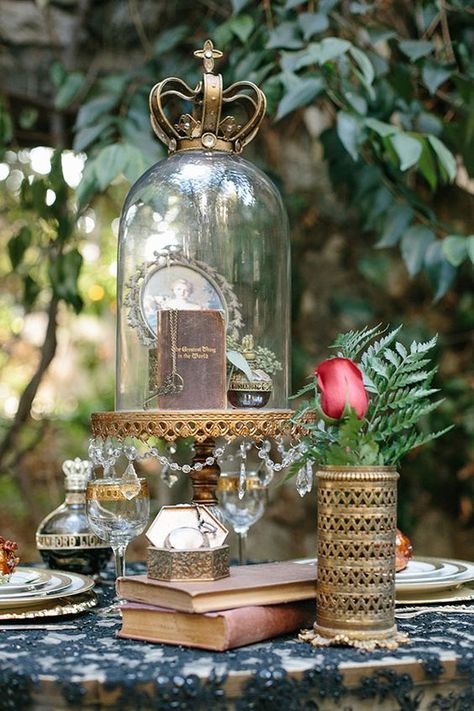 a cloche with a vintage book, key, a perfume and a framed portrait with a crown on top Dark Romance Wedding, Snow White Wedding, Casa Disney, Cloche Decor, Wedding Table Designs, Romance Wedding, Glass Cloche, Vancouver Wedding, Romantic Books