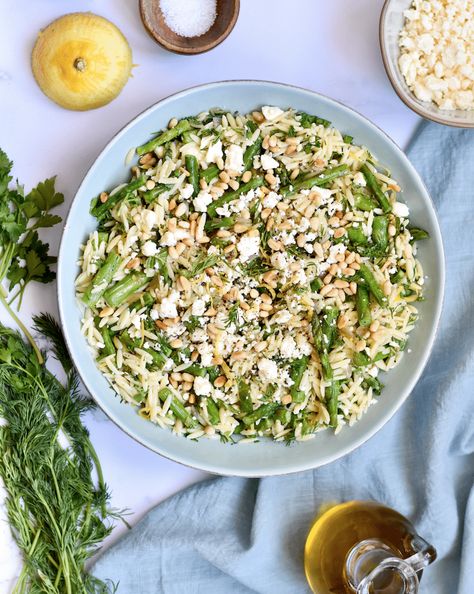 Asparagus Orzo With Lemon and Feta. Bright, lemony, and full of fresh herbs, this asparagus orzo salad with feta is a perfect meal to make when asparagus is in season. Crisp asparagus is paired with a lemon orzo with shallots, garlic, fresh herbs like mint, dill, and parsley and topped with tangy feta and crunchy toasted pine nuts. Asparagus Orzo Salad, Orzo Asparagus, Orzo Salad With Feta, Asparagus Orzo, Lemon Dill Salmon, Lemon Orzo Salad, Cauliflower Risotto, Spring Pasta, Creamy Asparagus