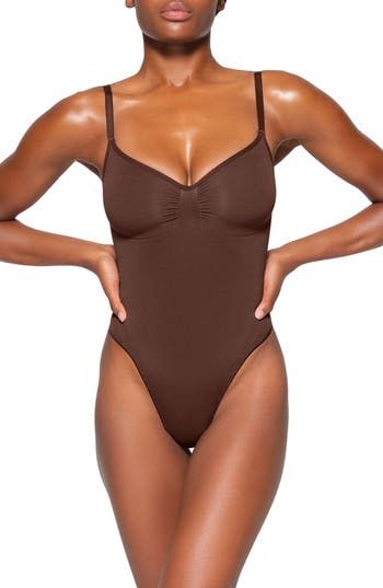 Updated for an even better fit, this fan-fave bodysuit from Kim Kardashian's SKIMS offers extra compression at the core and waist to cinch your natural shape. Strategically placed lines flatter your bust and provide definition, and the low back makes it easy to wear under a variety of outfits. Snap closure Scoop neck Adjustable straps Cotton-lined gusset 82% nylon, 18% spandex Machine wash, tumble dry Imported Sculpting Bodysuit, Teddy Bodysuit, Shapewear Bodysuit, Body Confidence, Teddy Lingerie, Creative Direction, Christmas List, Kim Kardashian, Shapewear