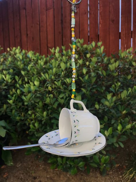 Mini Tea cup & saucer bird feeder. Sweet dainty wild flowers. Beautiful gift or for you to enjoy. The beads sparkle beautifully in the sunshine.  Slips on to a shepherds hook or hangs in a tree. This feeder is made with recycled pieces. The mini spoon is the perch.  What a fun addition to your garden and the birds will be blessed and love you! I will include a small pouch of seed to get you started. The pieces are put together with a strong adhesive to withstand the heat, cold and rain but would Tea Cups Diy, Cup And Saucer Crafts, Teapot Crafts, Glassware Garden Art, Easy Yarn Crafts, Glassware Crafts, Teacup Crafts, Bird Houses Ideas Diy, Tea Cup Bird Feeder