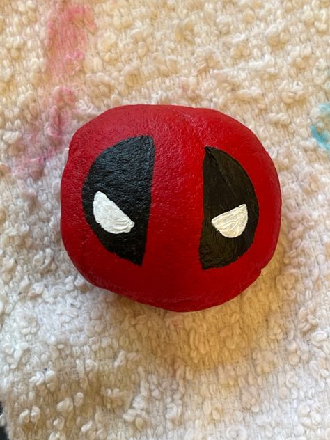 Easy Deadpool Rock Painting Idea DIY Deadpool Rock Painting, Horror Movie Rock Painting, Marvel Painted Rocks, Deadpool Pumpkin Painting, Rock Painting Ideas Big Rocks, Horror Rock Painting, Square Rock Painting Ideas, Rock Painting Disney, Rock Painting Ideas Funny