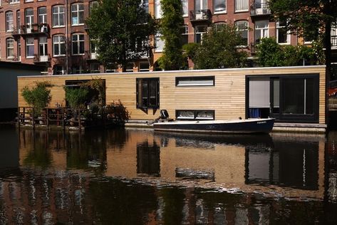 a long wooden sided houseboat with a small boat next to it Houseboat Vacation, Luxury Houseboats, Boat House Interior, Houseboat Living, Anne Frank House, Amsterdam Houses, Red Light District, Earth Homes, Floating House