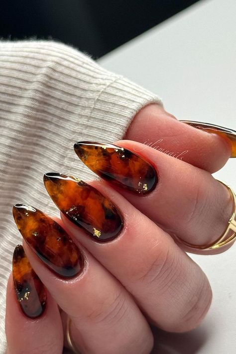 These almond-shaped nails feature a stunning tortoise shell design. Rich amber and brown tones blend seamlessly, creating a warm, organic pattern. Subtle gold flakes are carefully placed throughout, adding a touch of luxury to the sophisticated look. Each nail is beautifully glossy, amplifying the intricate details of the design. Perfect for a chic and polished style!  // Photo Credit: Instagram @iglamnails Tortishell Nails Design, Humans Are Weird, Tortoise Shell Nails, Shell Nails, Sophisticated Manicure, Acrylic Nails Almond Shape, Oval Shaped Nails, Cute Tortoise, Manicure Art