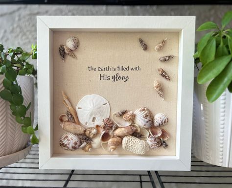 8 x 8 original, one-of-a-kind shell art in a glass-front shadow box. Seashells were ethically collected from Southwest Florida beaches, and thoroughly cleaned and organically polished. Text is printed on fabric for a natural look. *This piece features a beautiful sand dollar among ceriths, chestnut turbans, Florida pricklycockles and many others. You can't help but praise His Glory when you think about all the variations in the shells are so intricate and unique! *Please note that I take my collected shells through a multi-step cleaning process... but you never know if a little sand is deep within certain shells. Consider finding a granule within the box a bonus feature as something may come out in shipping. Please also note that as these are authentic gulf shells, you will see natural var What To Do With Sea Shells, Florida Crafts, Beach Shadow Boxes, Seashell Shadow Boxes, Sand Dollar Art, Shell Artwork, Shell Animals, The Goodness Of God, Goodness Of God