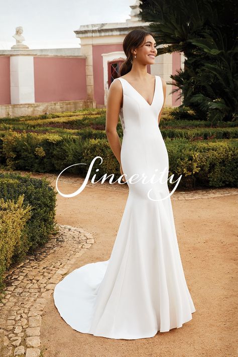 This stretch crepe fit and flare wedding gown is sophisticated with a pop of feminine detail. The sleek silhouette features a low V-back with ruched tulle and floral Appliqués. Clean lines draw the eye while buttons extend to the end of the train for an elegant finish. Simple Fishtail Wedding Dress, Simple Wedding Dress Fit And Flare, Clean A Line Wedding Dress, Stretch Crepe Wedding Dress, Fit N Flare Wedding Dress, Slim Fit Wedding Dresses, Sincerity Wedding Dress, Flattering Wedding Dress, Fit And Flare Dresses