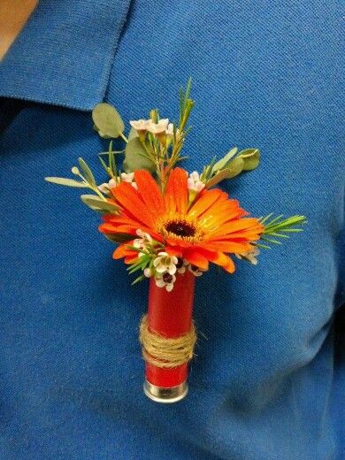 A unique boutonniere: an orange Gerbera daisy in a shotgun shell Orange Corsage, Boutonniere Diy, Unique Boutonniere, Shell Boutonniere, Blue Red Wedding, Orange Boutonniere, Orange Gerbera, Teal Burgundy, Bouquets Ideas