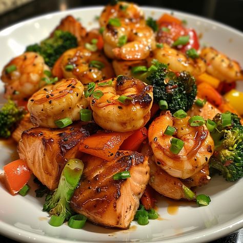 🍯🍤 Savor the sweet and savory Honey Glazed Salmon and Shrimp Stir-Fry! 🍲✨ #HoneyGlazedStirFry #SeafoodDelight Honey Glazed Salmon and Shrimp Stir-Fry Ingredients: Salmon fillets, cubed (1 lb) Shrimp, peeled and deveined (1 lb) Bell peppers, sliced (2) Broccoli florets (2 cups) Honey (1/4 cup) Soy sauce (1/4 cup) Garlic, minced (3 cloves) Olive oil (2 tbsp) Salt and pepper (to taste) Green onions, chopped (1/4 cup) Instructions: In a bowl, mix honey, soy sauce, and garlic. Heat olive oil i... Salmon And Shrimp Dinner Ideas, Honey Glazed Salmon, Salmon And Shrimp, Honey Soy, Honey Glazed, Easy Healthy Meal Prep, Healthy Food Dishes, Glazed Salmon, Food Babe