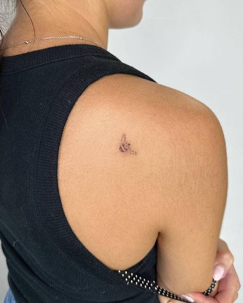 Single needle tiny bee tattoo placed on the shoulder Single Line Bee Tattoo, Bee Tattoo Shoulder, Ladybug And Bee Tattoo, Bee Shoulder Tattoo, Tiny Shoulder Tattoo, Bee Tattoo Placement, Tiny Animal Tattoos, Tiny Bee Tattoo, Bestie Tats