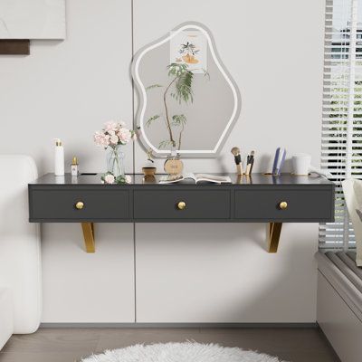 This contemporary makeup vanity elevates the experience of daily rituals. Its floating design is a space-saving marvel, featuring a sleek MDF and glass top supported by elegant gold metal brackets. With its built-in electronic equipment holder and various-sized pails, it's ingeniously designed to organize blow dryers and makeup tools, making it an ideal choice for both makeup and hairdressing needs. The wall-mount setup allows for customized height, ensuring ergonomic comfort. This piece doesn't Hanging Makeup Vanity, Diy Floating Vanity Makeup, Small Bathroom Makeup Vanity, Make Up Vanity In Bathroom, Small Space Vanity Ideas, Built In Makeup Vanity In Bathroom, Small Makeup Area, Floating Vanity Makeup, Make Up Vanities