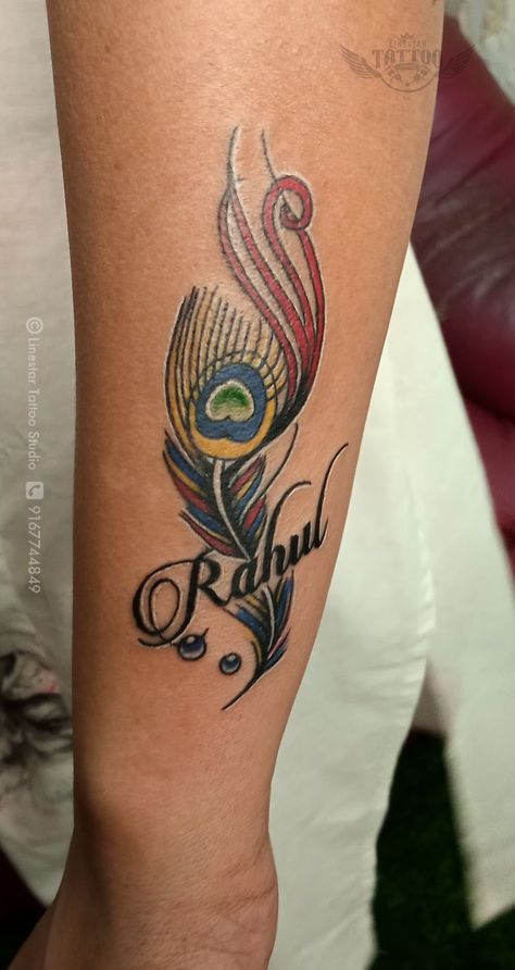 peacock feather tattoo with name coloured peacock feather tattoo done by Linestar Tattoo Studio,wadala,Mumbai Feather Tattoo With Name, Feather Outline, Baby Tattoo Designs, Tattoo Design For Hand, Family Tattoo Designs, Peacock Feather Tattoo, Band Tattoo Designs, Shiva Tattoo Design, Cool Forearm Tattoos