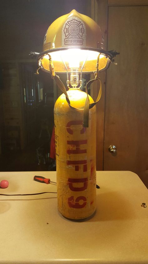 My husband is pretty crafty. He took a old scba bottle and a helmet and turned it into a lamp. He spray painted his department and his fire # on it. Old Fire Extinguisher Ideas, Firefighter Bar, Fire Extinguisher Lamps, Fire Hose Projects, Fire Hydrant Lamp, Fire Department Decor, Fire Dept Decor, Firefighter Room, Vintage Fire Extinguisher