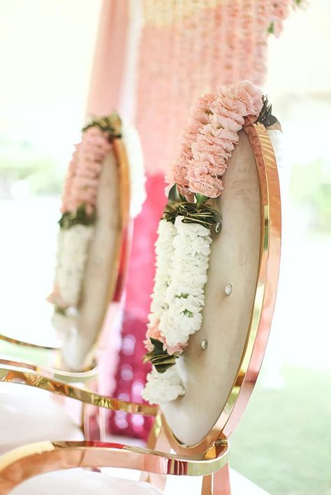 These light pink and white garland colors matched perfectly on gold chairs for this Indian Wedding Ceremony planned by wedding planners at Mountain Occasions, located in Denver Colorado. #southasianwedding #indianwedding #southasianweddings #indianweddingplanner #indianbride #southasianweddingplanner #southasianbride #mountainwedding #mountainweddingplanner #destinationweddingplanner Pink And White Garland, Pink Flower Garland, Indian Wedding Deco, Indian Wedding Garland, Wedding In The Mountains, Wedding Flower Jewelry, White Garland, Garland Wedding Decor, Wedding Hall Decorations