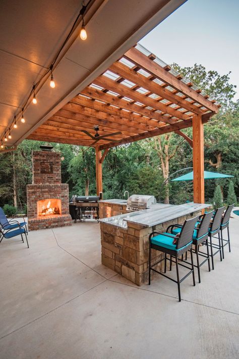 A custom outdoor kitchen, pergola, and fireplace turn this space into the ultimate fall hangout spot! Pool Pergola With Fireplace, Outdoor Fireplace With Kitchen, Sunken Fire Pit With Seating, Pergola And Fireplace, Pergola With Fireplace, Fall Hangout, Outdoor Kitchen Pergola, Kitchen Pergola, Kitchen With Fireplace