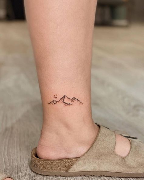 Mountain tattoo located on the ankle. Mountains On Ankle Tattoo, Moutain Tattoos Ankle, Mountain Range Ankle Tattoo, Mountain And Stars Tattoo Simple, Mountain Dainty Tattoo, Dainty Mountain Tattoo Simple, Exploration Tattoo Ideas, 14er Tattoo, Mountain Tattoo Back Of Neck