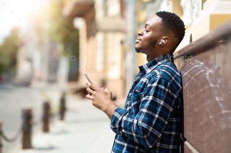 Portrait of guy listening to music leaning against wall by Prostock-studio. Music Lover. Side view of dreamy african man with closed eyes holding phone, listening to song, leaning against wall #Sponsored #Prostock, #wall, #studio, #Lover Guy Listening To Music, Leaning Against Wall, Holding Phone, Black Hipster, Studio Music, American Guy, Listen To Song, Black Person, Phone Service