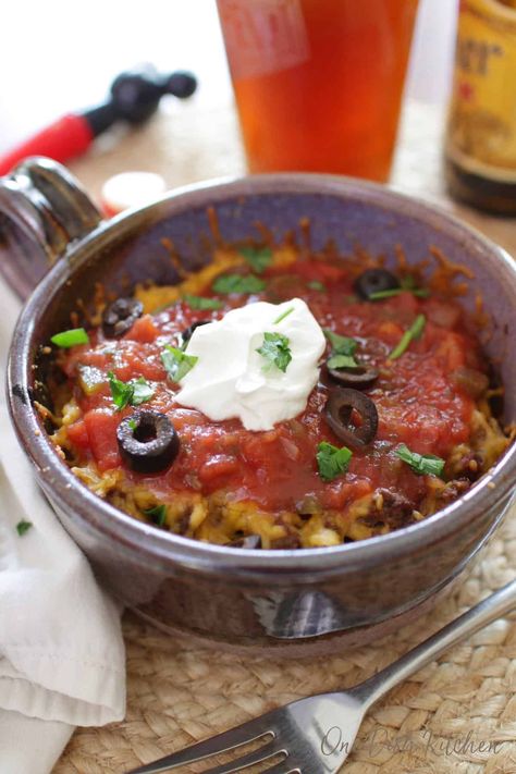 You won't believe how easy it is to make this Taco Casserole! Add seasoned ground beef and cheese between crisp layers of crunchy tostadas and bake in the oven. A quick, easy, and tasty single serving meal.| One Dish Kitchen Casserole For One, Single Meals, Southwestern Dishes, Ramekin Recipes, Cook Videos, Hotel Meals, Easy Taco Casserole, Mini Meals, Beef Casseroles