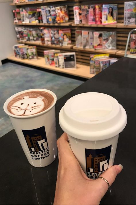 Girl holding two cups coffee, in front of a magazine stand. One cup has latte art of a bear in the foam. Seattle Coffee, A Love Letter, First Coffee, Cape Town South Africa, Coffee Company, But First Coffee, Letter I, Coffee Shops, Love Letter