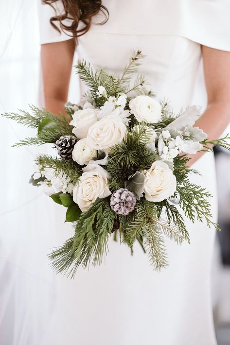 Elegant Winter Wedding Bouquet | A beautiful winter wedding bouquet featuring white roses, pine greenery, and frosted pinecones. See more winter wedding flowers, winter wedding florals, elegant wedding bouquet. Book Nina for your Colorado wedding or elopement at larsenphoto.co! Pinecone Wedding Bouquet, Evergreen Bouquet Wedding, Winter Wedding White Flowers, All White Winter Wedding, Winter Wedding Bouquet Evergreen, Christmas Wedding Bouquet, Christmas Wedding Bouquets, Winter Wedding Accessories, Winter Bridal Bouquets