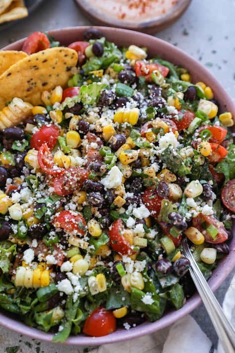 Crisp fresh lettuce, black beans, juicy tomatoes, sweet corn & green onion all tossed in a creamy homemade taco dressing & sprinkled with cotija cheese! This Mexican chopped salad is the perfect side dish for all your favorite Mexican recipes! Taco Dressing, Mexican Chopped Salad, Mexican Salad Recipes, Mexican Salads, Chopped Salad Recipes, Cotija Cheese, Potluck Dishes, Juicy Tomatoes, Green Onion