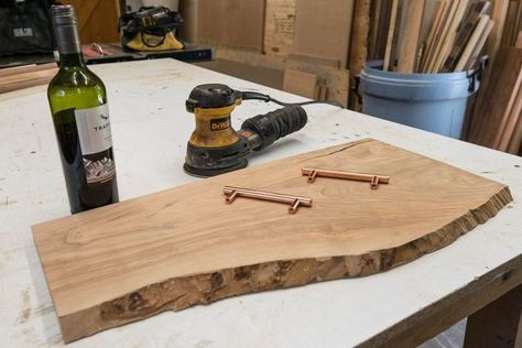 How to turn a piece of live edge olive wood into a stylish serving board. So here's everything I used in the project. A slab of live edge olive wood that I purchased from a local mill, some left over wine from a dinner party, and 2 rose gold handles I bought from Lowes. The first thing I did was cut 3 sides of the board. I wanted to keep the front edges original character so I left that unchanged, but I wanted the other 3 sides of the serving board to be square with one another.… Live Edge Wood Projects, Live Edge Wood Desk, Tree Stump Side Table, Live Edge Shelves, Narrow Sofa Table, Floating Bathroom Vanities, Rustic Desk, Dining Room Sideboard, Live Edge Coffee Table