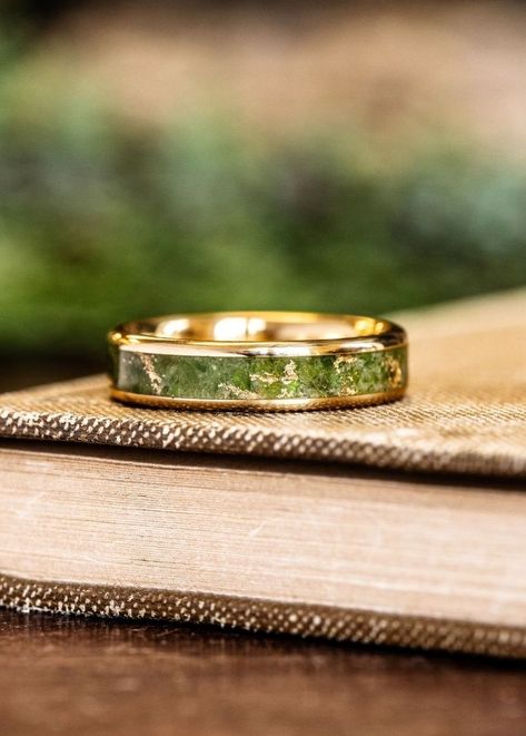 custom 18k yellow gold ring green imperial diopside gold flakes inlay laying on book rustic and main Non Traditional Wedding Bands Men, Mens Alternative Wedding Band, Peridot Wedding Band Men, Peridot Ring Men, Peridot Ring For Men, Unique Engagement Rings Men, Gemstone Rings For Men, Unique Rings For Men, Ring Designs For Men