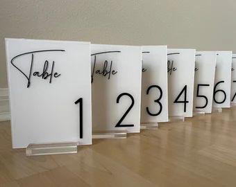 Acrylic table numbers with stand | Etsy Wedding Table Numbers Tall, Acrylic Table Number Signs, Table Numbers For Restaurant, Table Acrylic Signs, Square Table Numbers, Black Table Signs Wedding, Black Tie Wedding Table Numbers, White Acrylic Table Numbers, White And Black Table Numbers