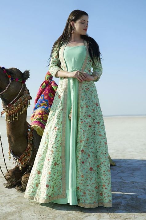 Leave a mark with this demure sea green colored designer anarkali suit falling plain all over with a front open jacket featuring string tie-ups and kundan border layering the suit for glam. Jacket is done up all over in lovely resham & zari floral patterns in a blissful feel! This suit is accompanied by matching leggings. Long Gown Dress, Long Dress Design, Salwar Kamiz, Indian Gowns Dresses, Kurti Designs Party Wear, Indian Gowns, Party Kleidung, Stylish Party Dresses, Party Wear Indian Dresses