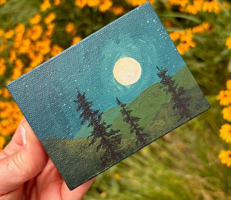 This one of a kind painting is 4 inches wide by 3 inches high. Original Acrylic Painting on Canvas with mini easel Title: Moon, Tree and Hills These tiny paintings are so fun and versatile. They can be propped on a shelf, on an easel, framed or hung as is. I initialed the front and signed, dated and titled the back. Painting On Small Canvas, Canvas Easel, Tiny Paintings, Tiny Canvas, Moon Tree, Mini Easel, Shelf Desk, Paint Nite, Desk Dresser