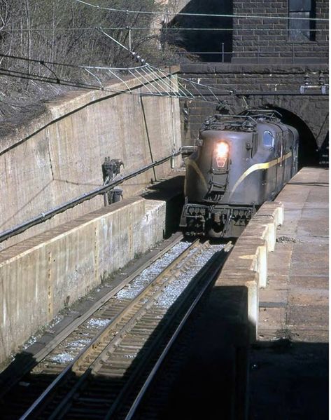 1961 sees a GG1 exiting the North River Tunnel, North Tube. The portal house above the portal and the third rail give it away, along with the high concrete walls. Lionel Trains Layout, Metro North Railroad, Union Pacific Train, Ho Scale Train Layout, Third Rail, Railroad Art, Commuter Train, Penn Station, Concrete Walls