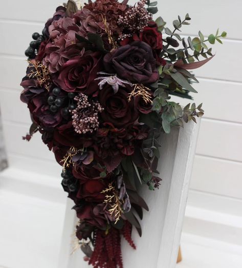 Embrace the allure of romance with this captivating cascading bouquet. Rich burgundy roses and delicate hydrangeas blend seamlessly with lush foliage and hints of gold, creating an elegant and dramatic statement piece for your special day. Perfect for brides seeking a touch of vintage glamour and timeless sophistication. 💍✨ #CascadingBouquet #WeddingFlowers #BridalBouquet #burgundywedding #cascadingflowers #darkwedding #weddindflorist #WeddingBouquets #weddingvendor Maroon Wedding Flowers, Burgundy Roses, Cascading Bouquet, Cascading Flowers, Maroon Wedding, Dark Wedding, Dark Maroon, Cascade Bouquet, Rich Burgundy