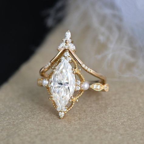 2ct Marquise Moissanite Pearl Engagement Ring Set Yellow Gold Moissanite Chevron Band Vintage Bridal Set 2pcs Flower Halo Ring art deco Milgrain * Ring Material: solid 14k white gold, rose gold, or yellow gold  * Center Stone: Colorless Moissanite   5x10mm, about 1ct   6x12mm , about 2ct    7x14mm, about 3ct * Side Stone: Colorless Moissanite, Natural Pearls, about 0.28ct * Bandwidth: 1.6mm 2-3 WEEKS PROCESSING TIME MADE IN US * Shipping * FREE SHIPPING WITHIN THE USA! * Certificate * All the it Moissanite Engagement Ring Art Deco, Sparkly Engagement Rings, Pearl Engagement Ring Set, Marquise Moissanite Engagement Ring, Moissanite Wedding Set, Pretty Engagement Rings, Dream Wedding Ring, Milgrain Ring, Moissanite Engagement Ring Set