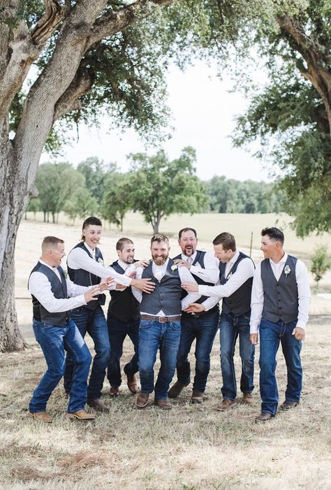 Groomsmen in grey vests and blue jeans point to the groom and cheer him on at Little Bear Creek Ranch. Dusty Blue Groomsmen Attire Jeans, Groomsmen Country Attire, Jeans And Vest Wedding Groomsmen, Blue Jean Wedding Men Groom Attire, Groomsmen Jeans, Blue Jean Wedding, Blue Groomsmen Attire, Groom In Jeans, Country Groomsmen