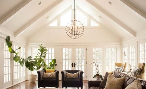 An airy family room surrounded with a french door and glass windows. It has a cathedral ceiling with a hanging industrial orb chandelier. Cathedral Ceiling Living Room, Vaulted Ceiling Lighting, Rustic Family Room, Miller House, Vaulted Ceiling Living Room, Traditional Family Room, Miller Homes, Faux Fireplace, Ceiling Lights Living Room