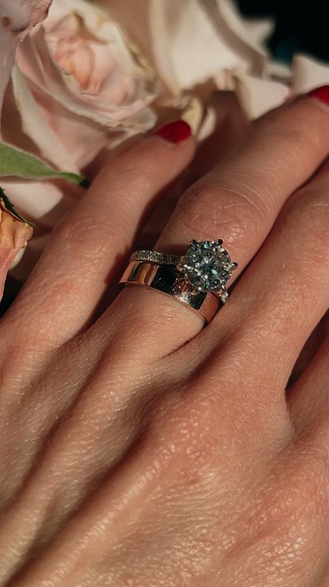 A hand with red nails on pink roses in the background with a White gold pave band, 1.5ct round diamond engagement ring with a 3mm thick rose gold cigar band on the ring finger Mixed Metals Wedding, Wedding Stack, Dream Wedding Ring, Plain Wedding Band, Round Solitaire Engagement Ring, Round Diamond Engagement Ring, Round Engagement Rings, Pave Engagement Ring, Wedding 2024