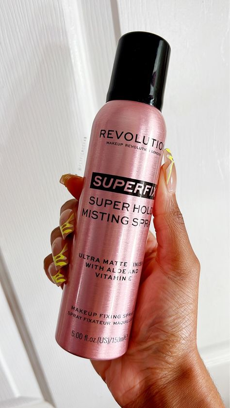 Black woman holding Makeup Revolution Superfix Makeup Fixing Spray Fixing Spray Makeup, Finishing Spray Makeup, Makeup Revolution Setting Spray, Best Makeup Setting Spray, Revolution Makeup, Fixing Spray, Makeup Spray, Finishing Spray, Makeup Setting Spray