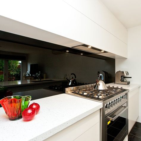 The boldness of a black, glass splashback; with beautiful white stone benchtop; and flush, push-to-open cabinetry. Black Benchtop, Black Splashback, Kitchen Splashback Ideas, Splashback Ideas, Best Kitchen Layout, Kitchen Black, Diy Kitchen Remodel, Kitchen Renovations, Kitchen Splashback