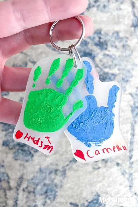 Making shrinky dink handprint keychains are so easy! They're the perfect sentimental gift for the amazing people in our children's lives - Dad, Mom, Grandparents and other special people. This a great craft for the kids to make, my boys love watching their handprints shrink before their eyes! You can add multiple handprints to the same keychain or add complimenting footprints too! | Get the tutorial from A Visual Merriment | Father's Day gift idea, Mother's Day craft, Grandparent Day DIY Handprint Keychain, Shrinky Dink Keychain, Kids Fathers Day Crafts, Grandparents Day Crafts, Handmade Kids Toys, Footprint Crafts, Shrinky Dink, Diy Gifts For Kids, Handprint Craft