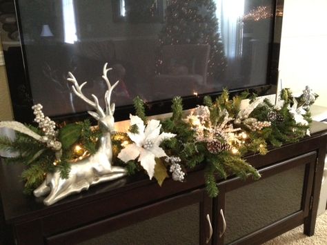 Garland in front of tv, would work as long as it doesn't edge into the frame.  (The BOYS would move it!) Tv Console Xmas Decor, Decorate Tv Stand For Christmas, Tv Table Christmas Decor, Tv Console Christmas Decor, Decorate Tv Stand, Tv Stand Christmas Decor, How To Decorate Around A Tv, Rain Deer, Christmas Layout