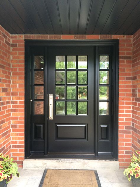 This richly black stained solid mahogany #Amberwood custom #door with 12 divided lights, looks stunning with the terracotta brick colouring of this home! The gorgeous entrance also features clear beveled glass and an #EmtekCraftsmanLockset in Satin Nickel! Call or come into Amberwood's outstanding showroom today and get your dream doors! 416-213-8007 #AmberwoodDoors proudly ships internationally! Call today for shipping details! 1-800-861-3591 Stained Front Door, Black Entry Doors, Black French Doors, Terracotta Brick, Painted Porch, Black Exterior Doors, Entry Door With Sidelights, Black Front Door, French Doors Exterior