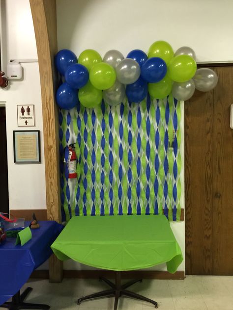 Blue, green and sliver wall decor with streamers and balloons. Blue Green Birthday Decor, Green And Blue Decorations Party, Green And Blue Party Decor, Green And Blue Birthday Party Decor, Green And Blue Party Decorations, Blue And Green Graduation Party, Seahawks Party, Football Party Decorations, Turtle Baby Shower