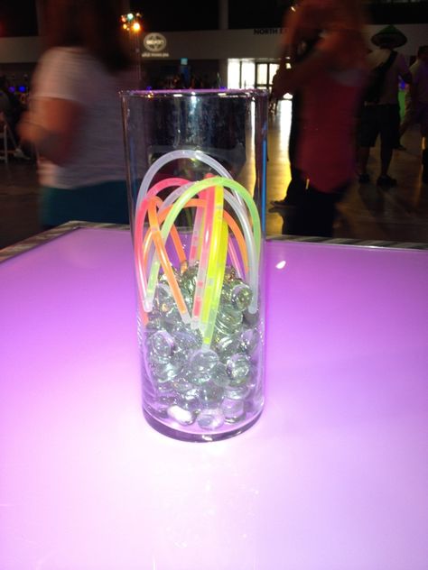 Simple centerpiece for any glow themed event/party - cylinder filled partially with clear gems and multiple glow bracelets  #FLeventdecor #centerpiece #glow #bracelets Pool Party Neon, Theme Dinners, Neon Dance, Ideas For Birthday Party, Neon Party Decorations, Perfume Ideas, Shark Pool, 70's Party, Simple Centerpiece