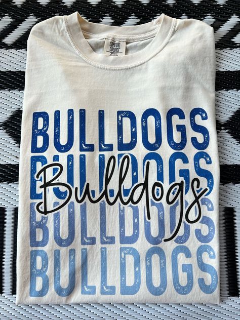 Get this popular new Bulldogs stacked text shirt and show off your school spirit in style!  Each shirt is printed in-house by me using high-quality materials on a Comfort Colors shirt, known for its exceptional comfort, style, and durability. Available in unisex sizes S to 3X, and youth sizes, we've got you covered regardless of your preferred fit. The Bulldogs stacked text Shirt features a classic crew neck and short sleeves, making it suitable for year-round wear. The flattering silhouette ensures a comfortable and stylish fit for both men and women. Please note that ivory is ONLY available in Adult sizes!  Note: As each shirt is individually printed, slight variations in color and placement may occur, adding to the uniqueness and charm of your Preppy Bulldogs Shirt. Your shirt will come Long Sleeve Cheer Shirts, Cheap Letter Print Tops For School Spirit, Cheap School Spirit Shirt With Funny Text, Cheap School Spirit Shirt For Game Day, Bulldog Volleyball Shirts, Middle School Spirit Wear, Sublimation School Spirit Shirts, Cricut School Spirit Ideas, Cheerleading Shirts Designs Spirit Wear