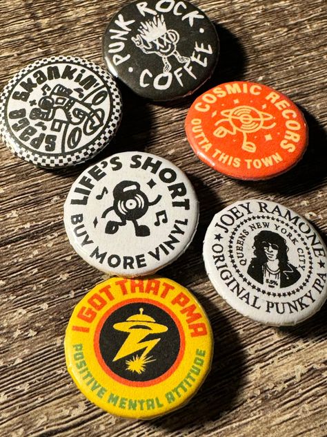 A collection of music inspired badges, based around my love for records and punk rock. Hand pressed by myself.  The pack includes:  * I got that PMA button badge (Bad Brains inspired) * Life's short buy more vinyl * Cosmic records  * Punk rock coffee * Space Skankin   * Joey Ramone original punky IPA * 25mm size * Metal badge case and plastic backer with pin  Free stickers with all orders. Design by: Jake Warrilow Punk Button Pins, Pins Design Button, Button Designs Ideas, Diy Pins Buttons, Button Pins Design, Button Pin Design Ideas, Pin Badge Design, Button Badge Design, Sticker Pack Design